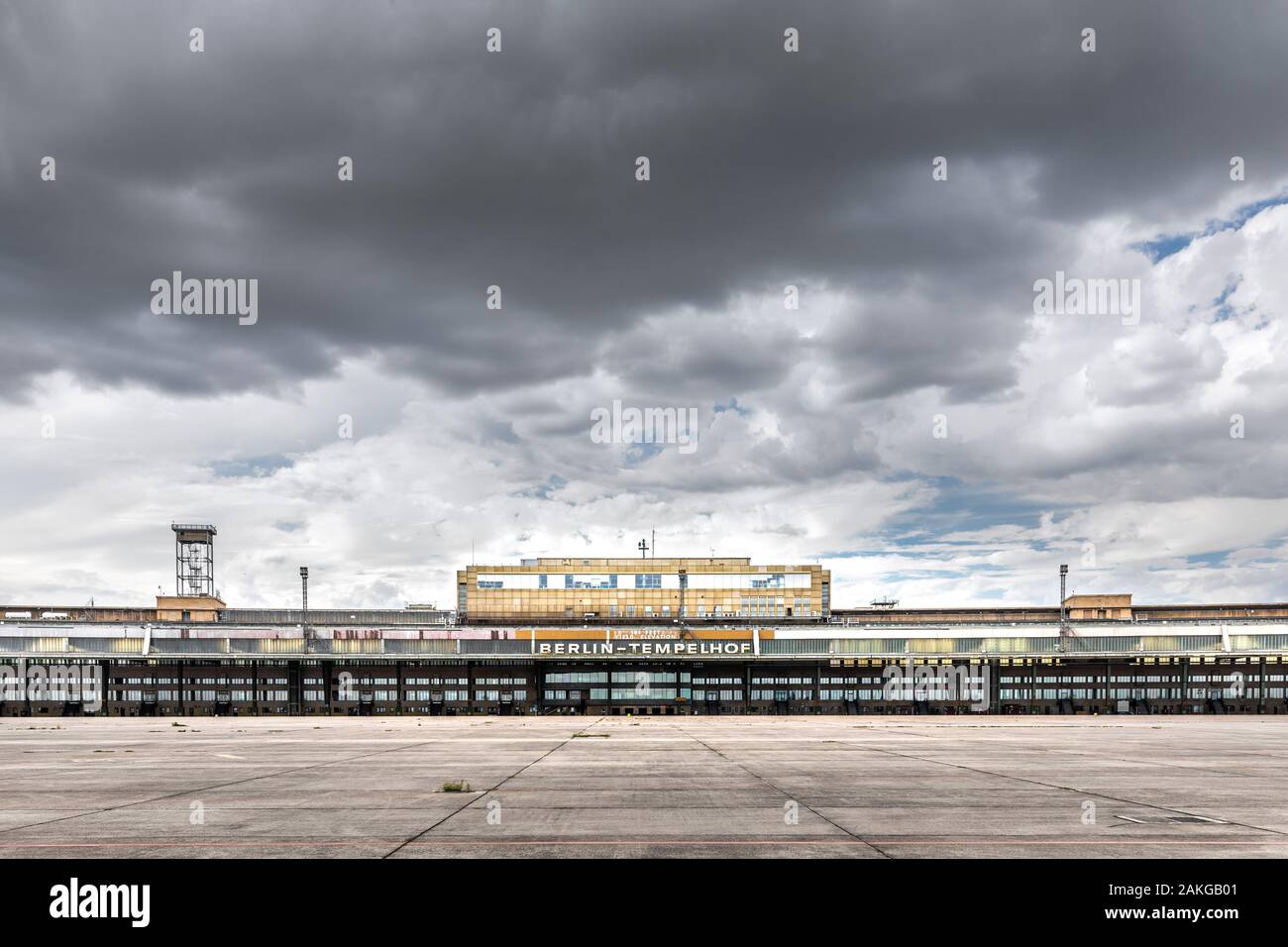 Vista simétrica, gran angular de la antigua y abandonada terminal del aeropuerto de Tempelhof en Berlín, bajo un cielo tormentoso de verano Foto de stock