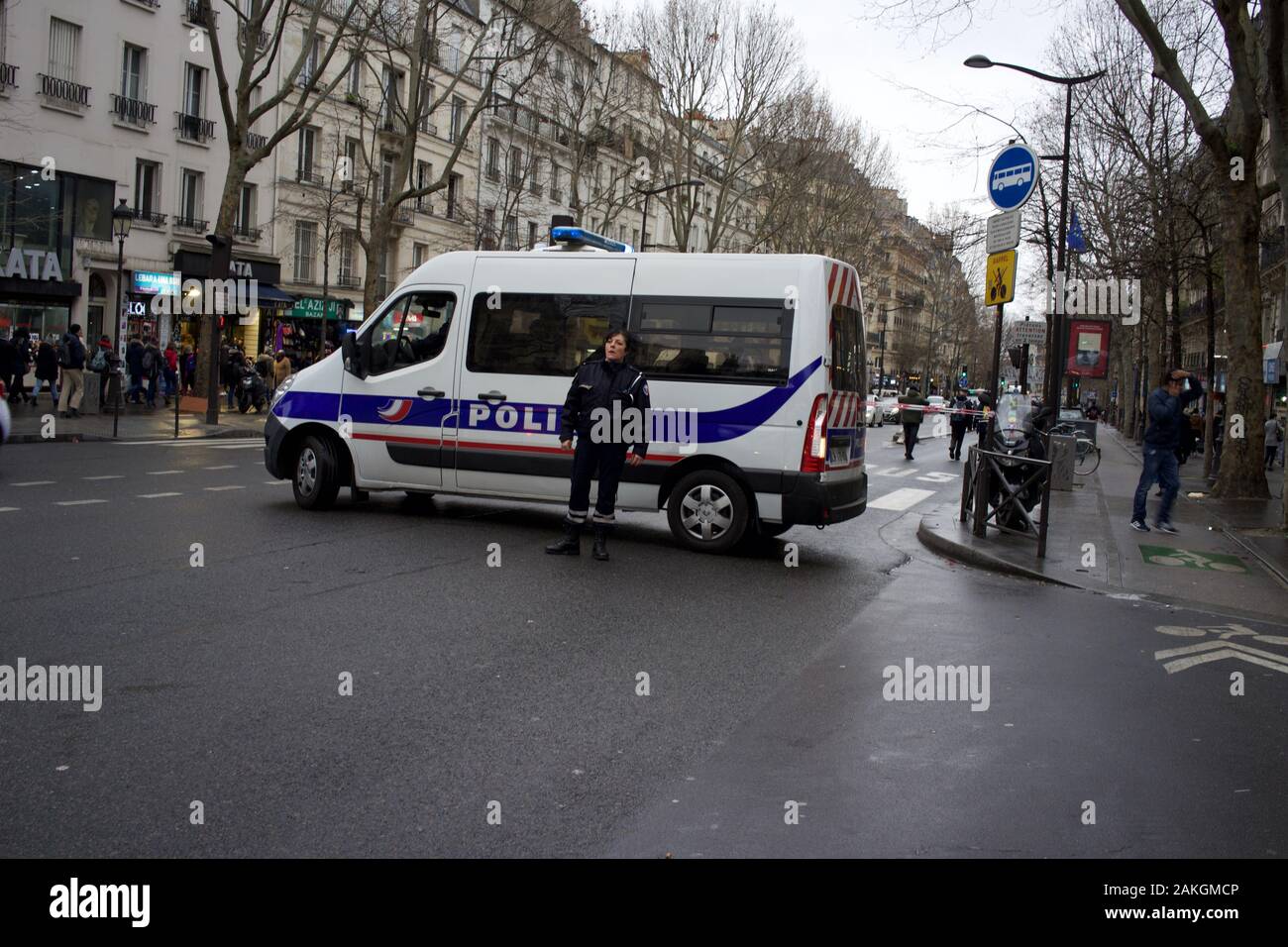 Vehículo policial estacionado en carretera y oficial, bloquear carretera al tráfico durante la huelga general, en previsión de la protesta, Place Jeanne-Bohec, 75018 París, enero de 2020 Foto de stock