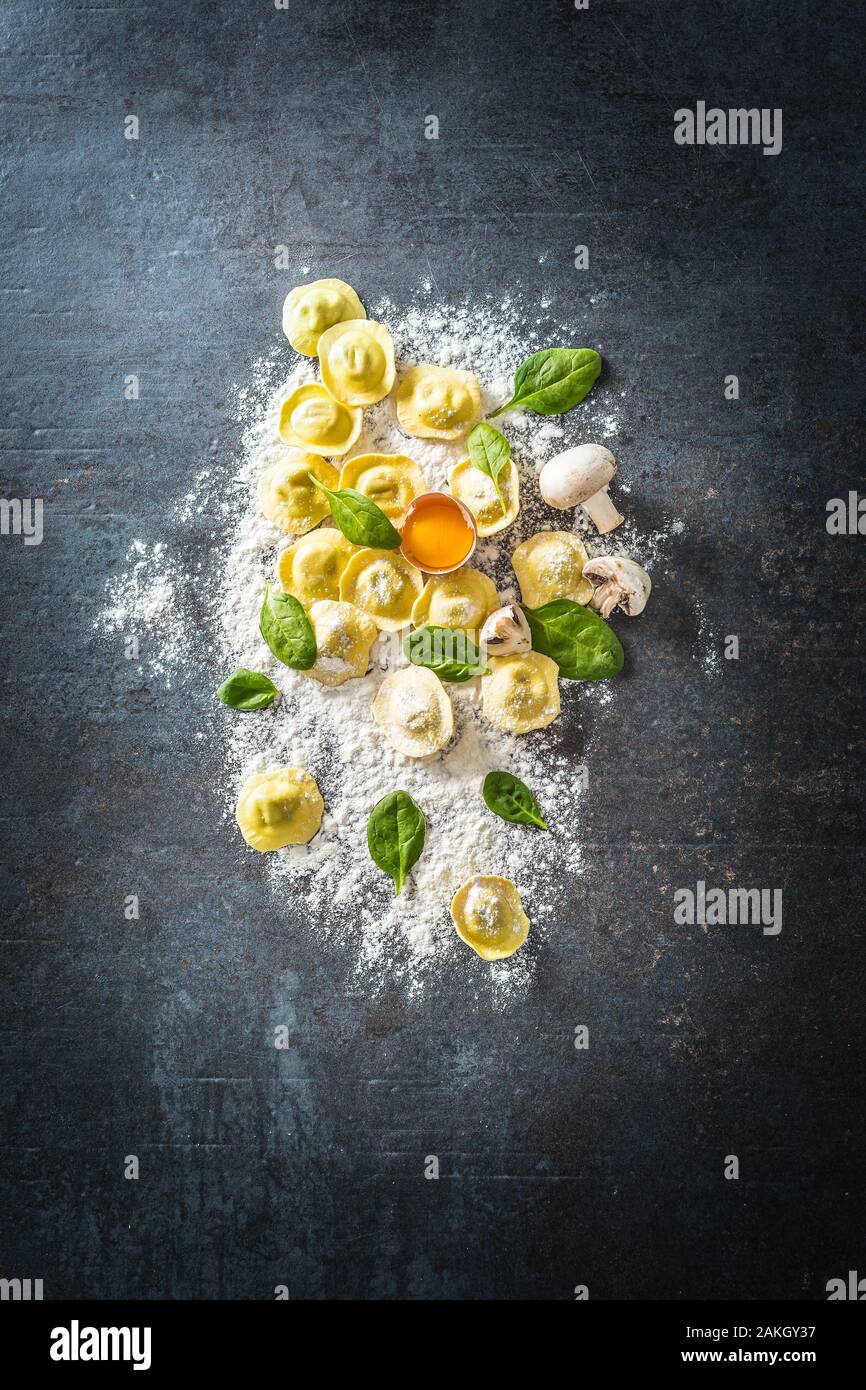Ravioles crudos con harina huevo musrooms y espinacas - la parte superior de la vista. Italiana o mediterránea cocina saludable Foto de stock