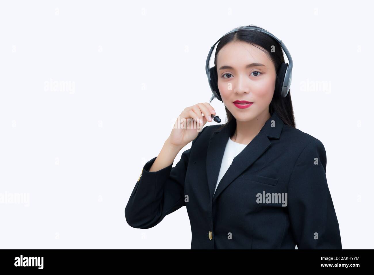 Hermosa mujer asiática sonriente hablando de servicio al cliente en los auriculares. Concepto de negocio. Foto de stock