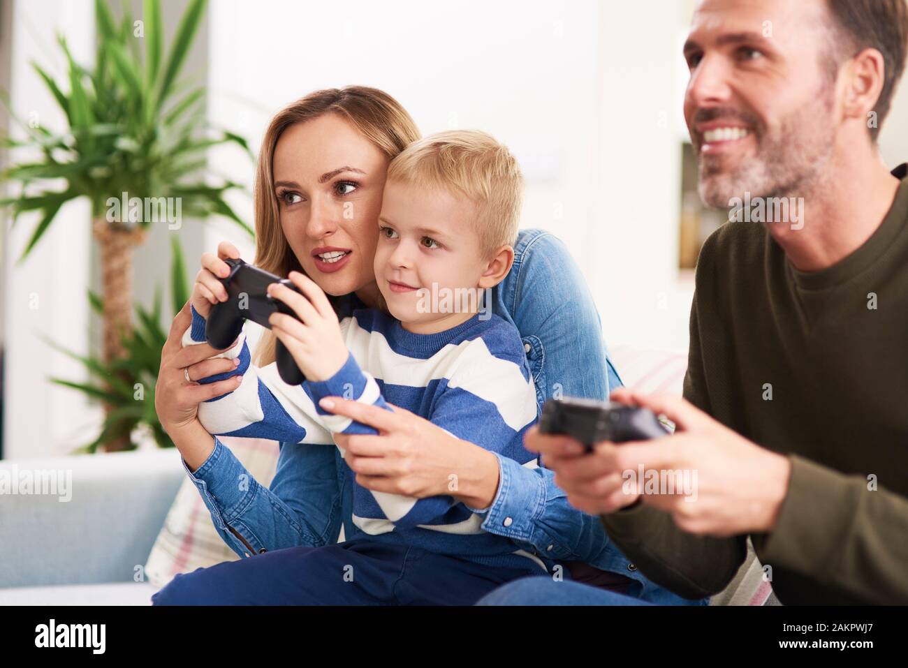 Los padres emocional e hijo jugando juegos de video Foto de stock