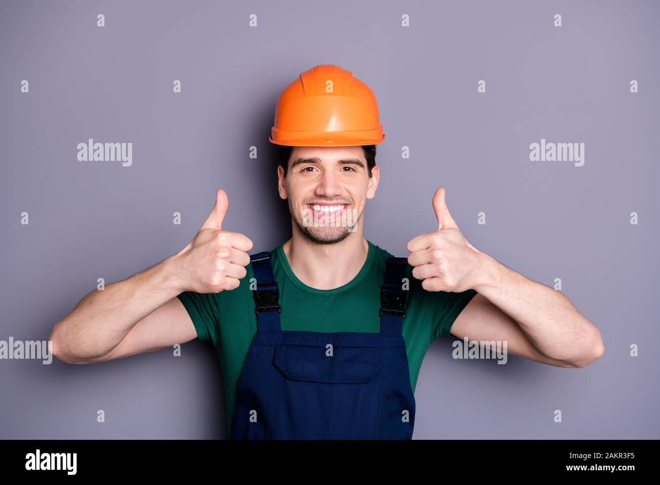 Foto de guapo masculino trabajador experto ingeniero levantar los dedos  pulgar para aconsejar de buena calidad llevar camiseta azul seguridad peto  protección Fotografía de stock - Alamy