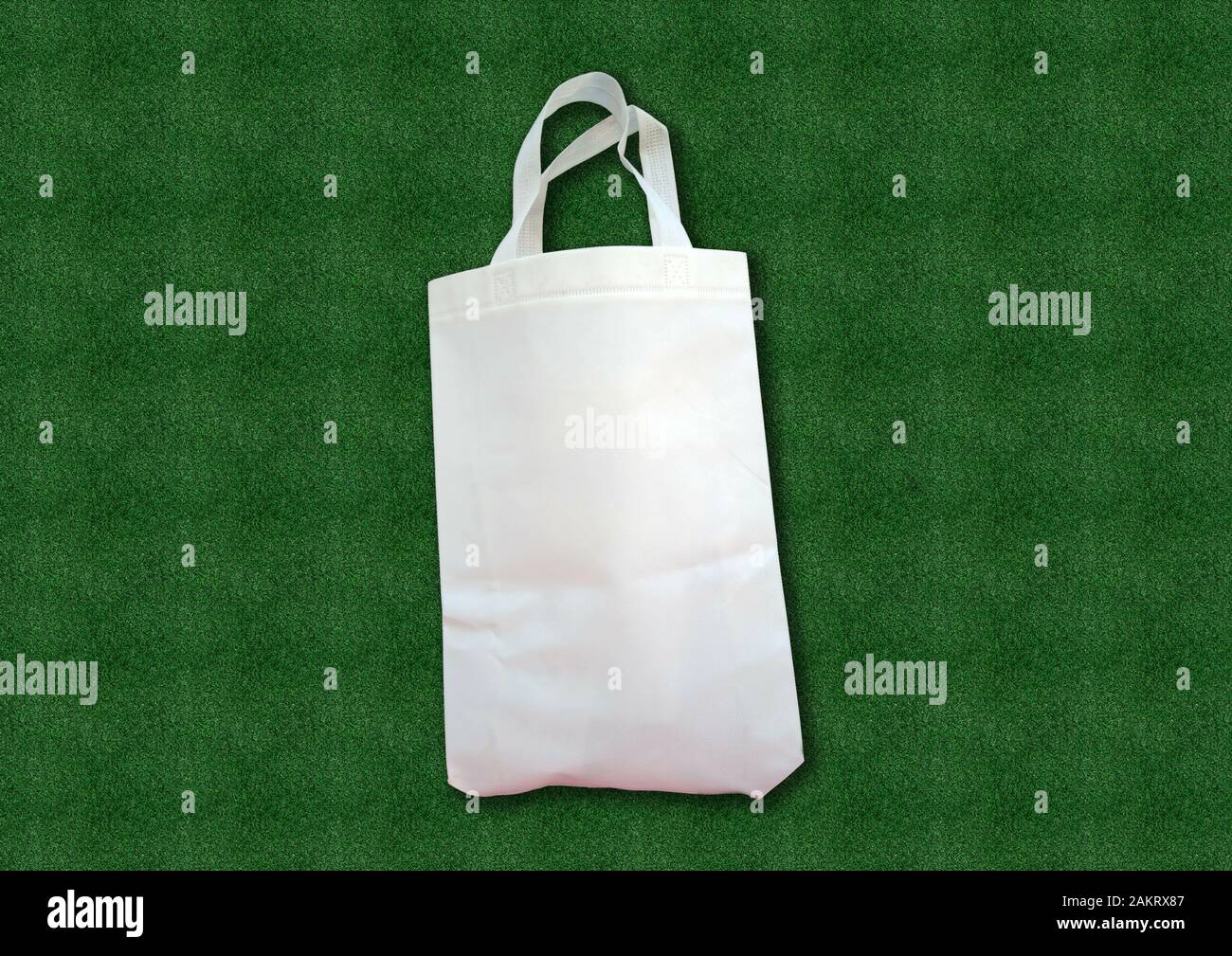 Un paño de tela blanca reciclable Bolsa ecológica sobre pasto verde de fondo. de la bolsa plástico. Salvar la Tierra ecología. Bolsa tejido buenas para el Medio Ambiente