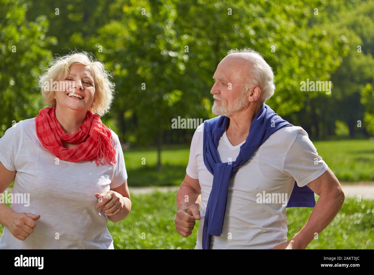 Dos ancianos sonrientes jog juntos en la naturaleza en verano Foto de stock