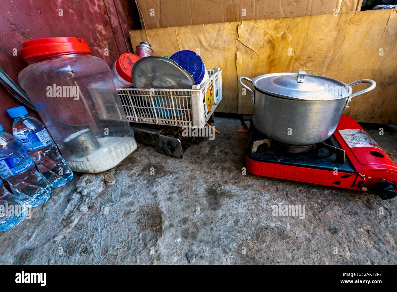 Utensilios de cocina descansar cerca de una estufa de gas propano y la olla  para cocinar los alimentos por pobres traperos en su cocina improvisada en  Kampong Cham, Camboya Fotografía de stock 