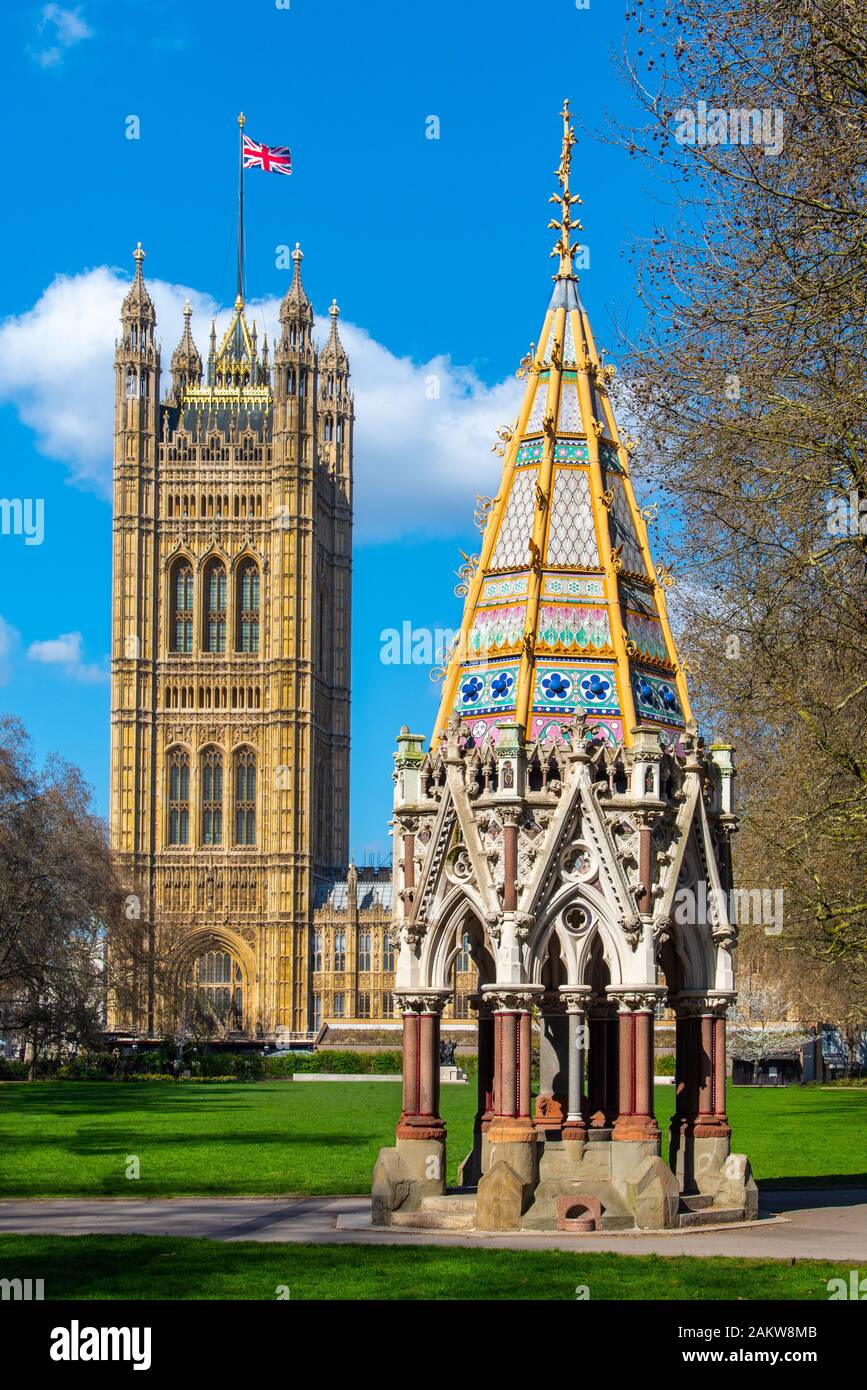 El Buxton Memorial Fountain y el Victoria torre del palacio de Westminster. Visto desde los jardines de la torre de Victoria, Westminster, Londres. Foto de stock