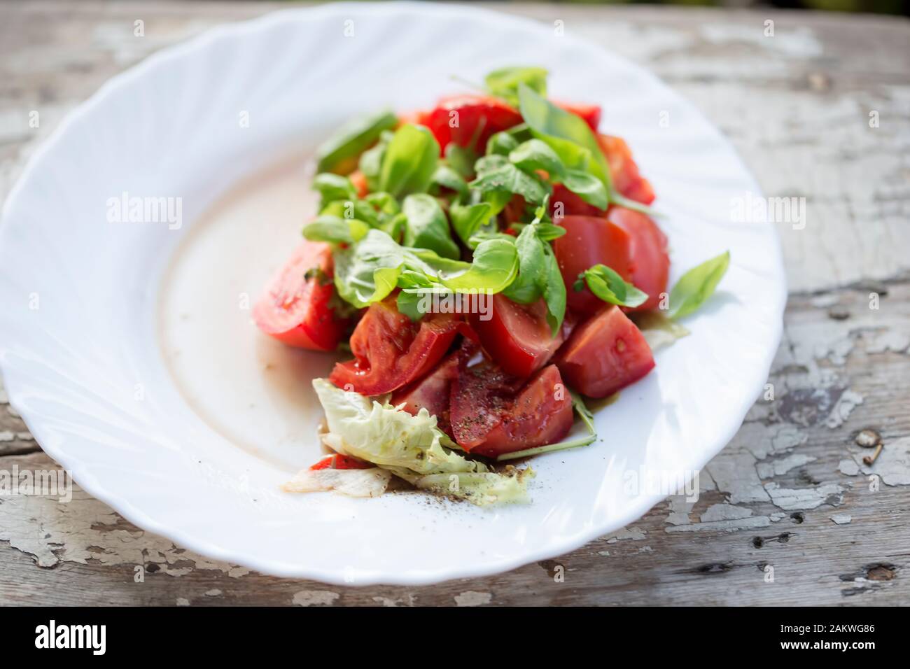 Ensalada de tomate con lechuga, albahaca y vinagreta Foto de stock