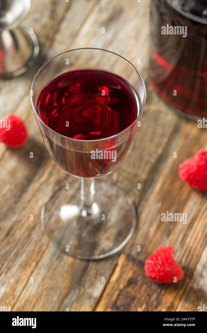 Rojo frambuesa orgánica en un vaso de licor Foto de stock