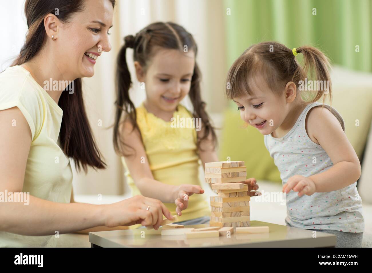 Familia está jugando a un juego de tablero en el salón Foto de stock