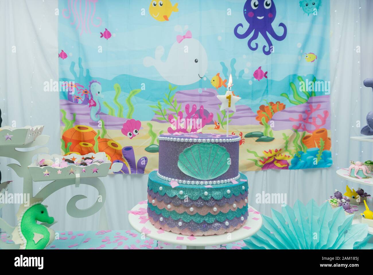 Vista general de la mesa de pastel decorada con el tema del fondo marino.  Fiesta infantil con pulpo, caballitos de mar, ostras, corales y globos  coloridos. Fiesta y diversión con Fotografía de