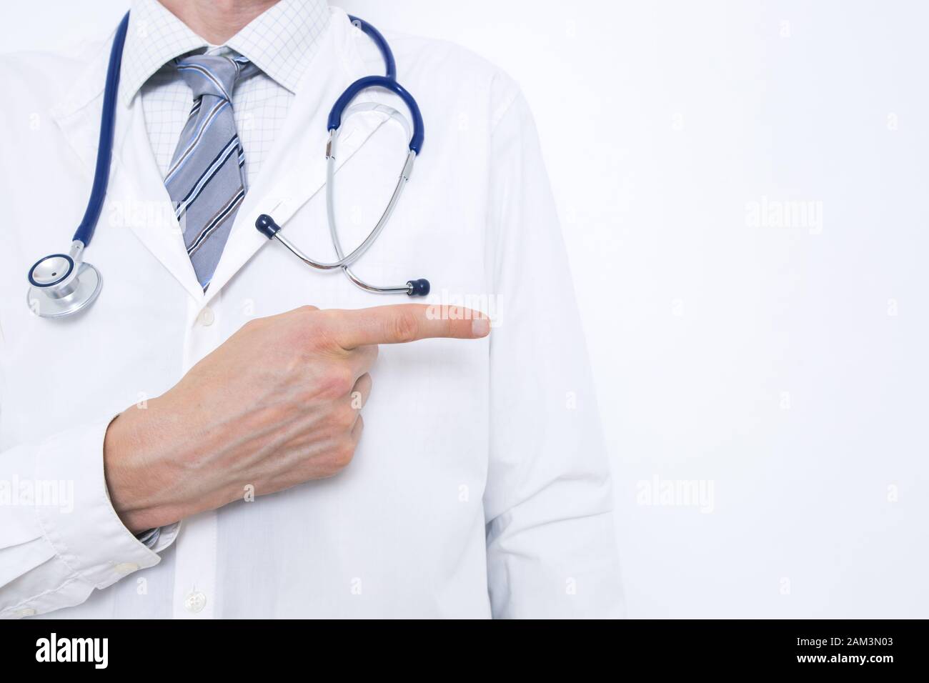 Un médico en una capa blanca señala un lugar para el texto. Foto de stock