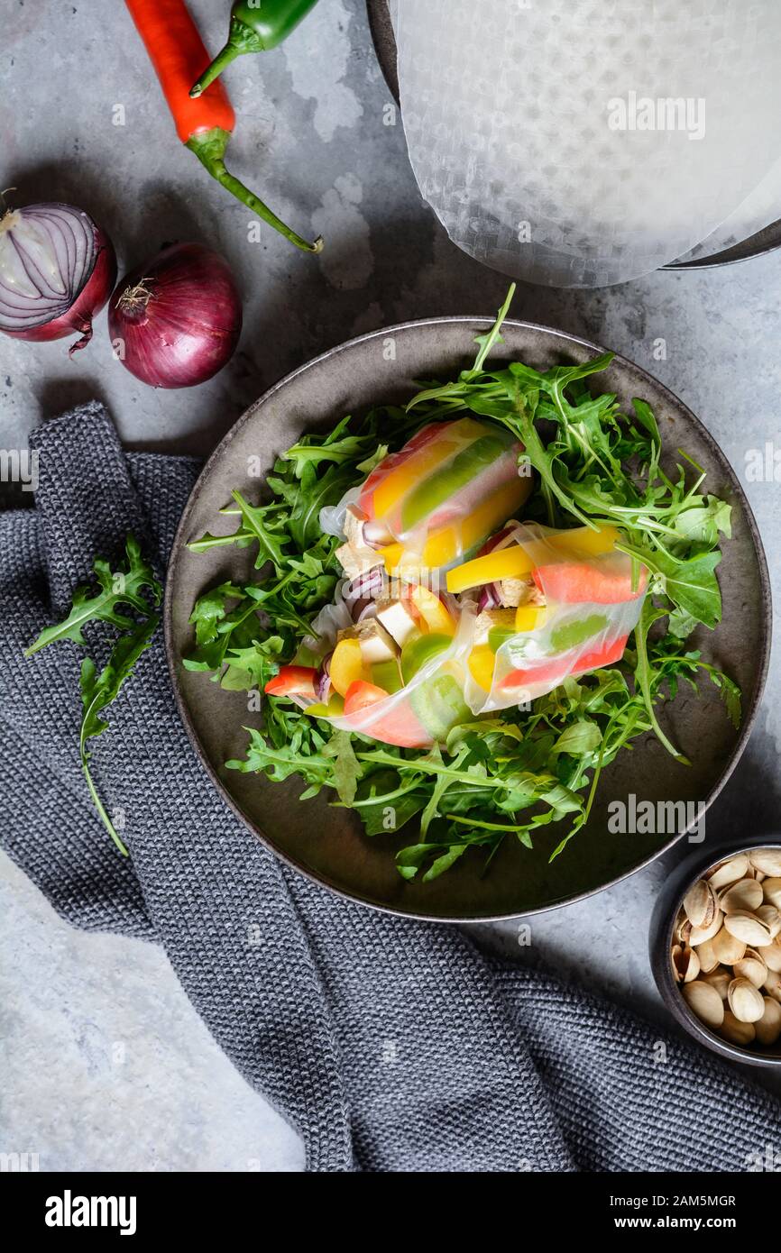 Merienda baja en calorías, pimiento, tofu ahumado y rollos de papel de arroz  de cebolla roja servidos con rúcula y pistachos frescos Fotografía de stock  - Alamy