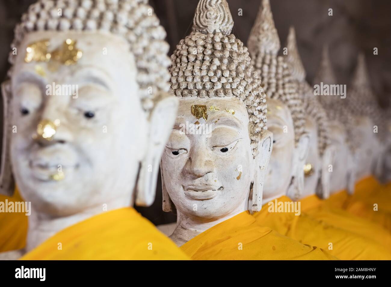 Fila de las estatuas de Buda tailandés en el templo budista Foto de stock