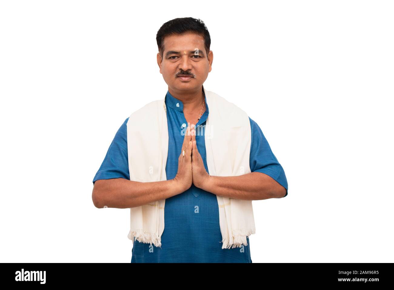 Hermoso hombre indio en la cerámica tradicional que muestra el gesto de namaste sobre fondo aislado. Foto de stock