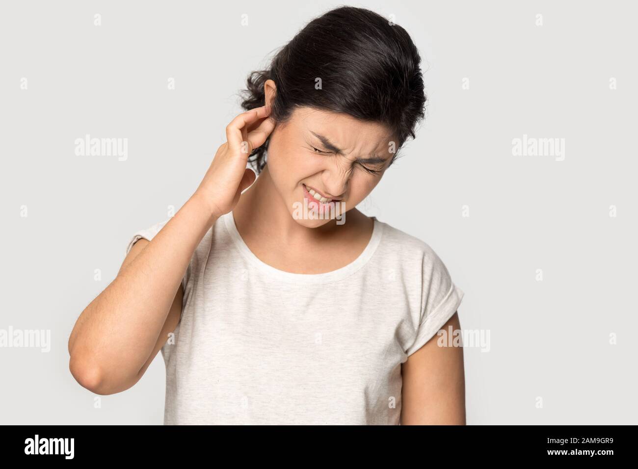 Mujer milenaria india malsana que sufre de dolor de oído fuerte. Foto de stock