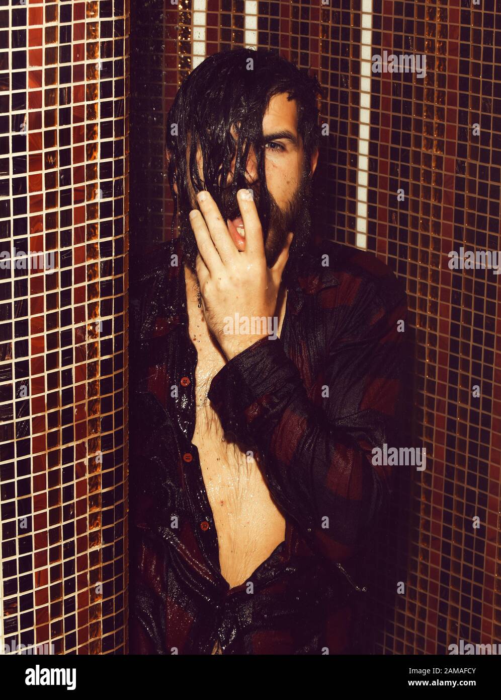 camisa de cuadros rojos y calzones húmedos con lavados de agua en la ducha  sobre fondo de mosaico colorido. Guapo hombre enojado, hipster barbudo con  barba y bigote adentro Fotografía de stock -