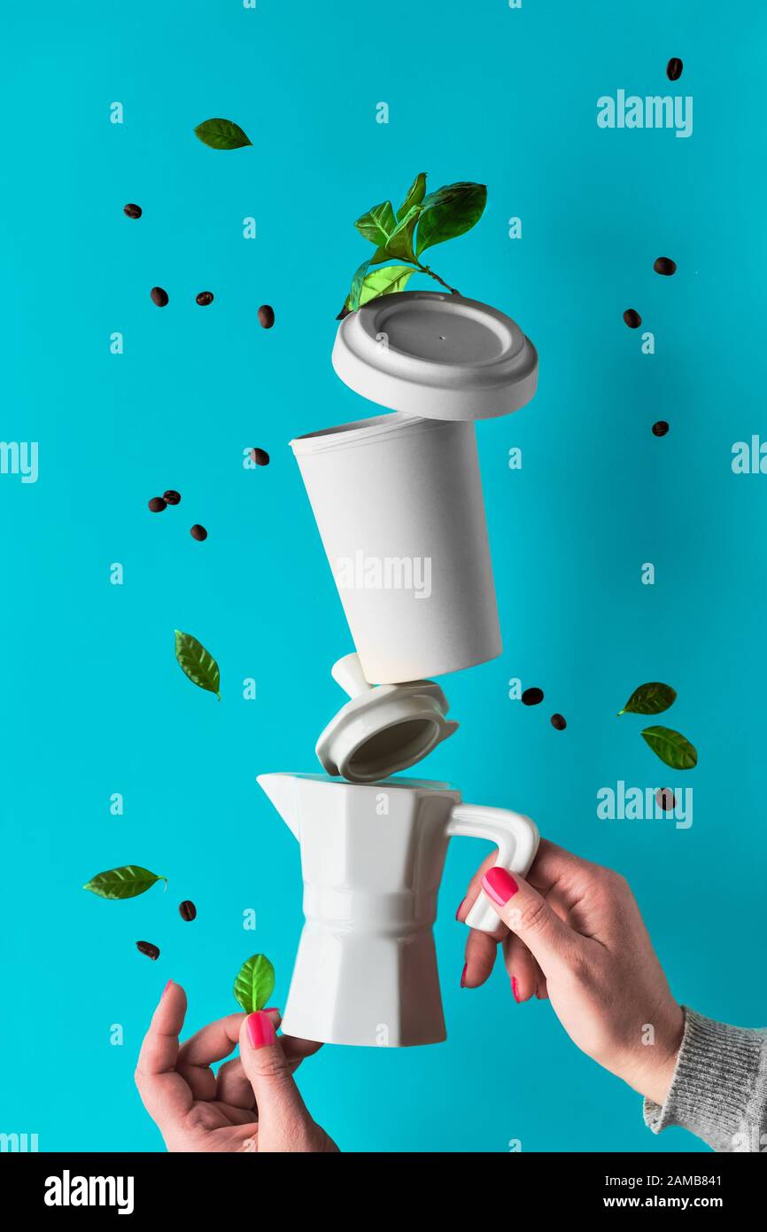 Equilibrio de cero basura pirámide de café en manos de mujeres sobre fondo  de menta azul. Cafetera espresso de cerámica y taza de café reutilizable de  bambú ecológica Fotografía de stock -