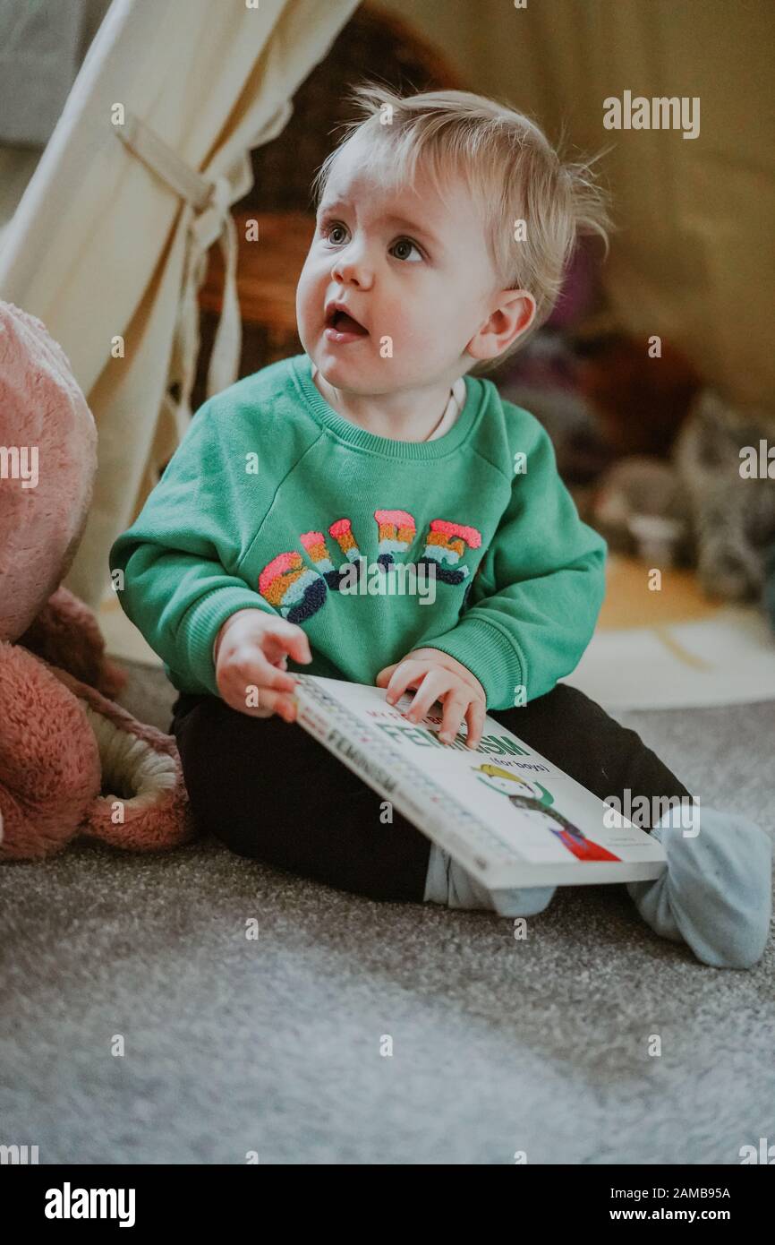 Niño pequeño leyendo 'Mi Primer libro de feminismo (para niños) por Julie Merberg Foto de stock