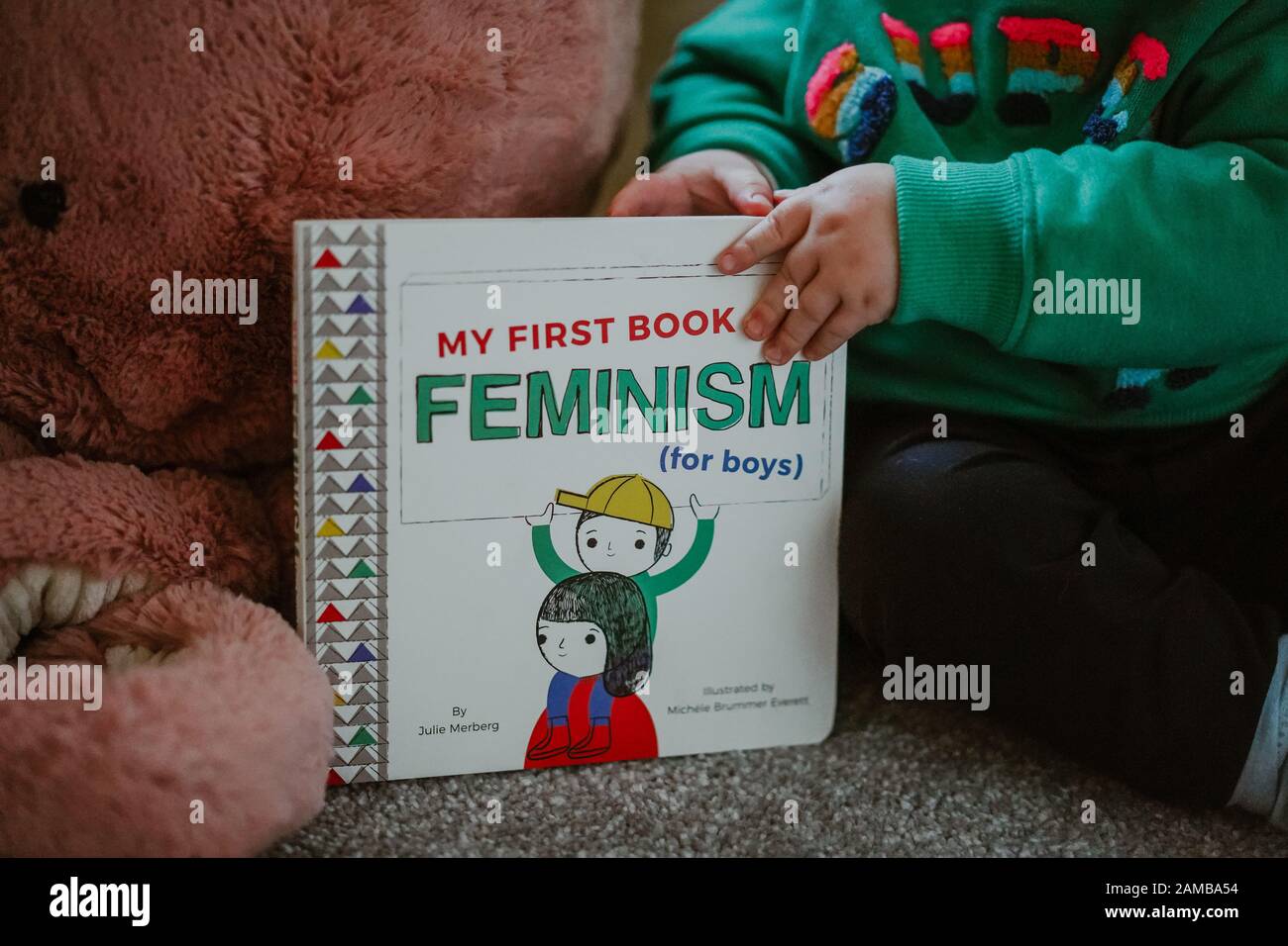 Niño pequeño leyendo 'Mi Primer libro de feminismo (para niños) por Julie Merberg Foto de stock