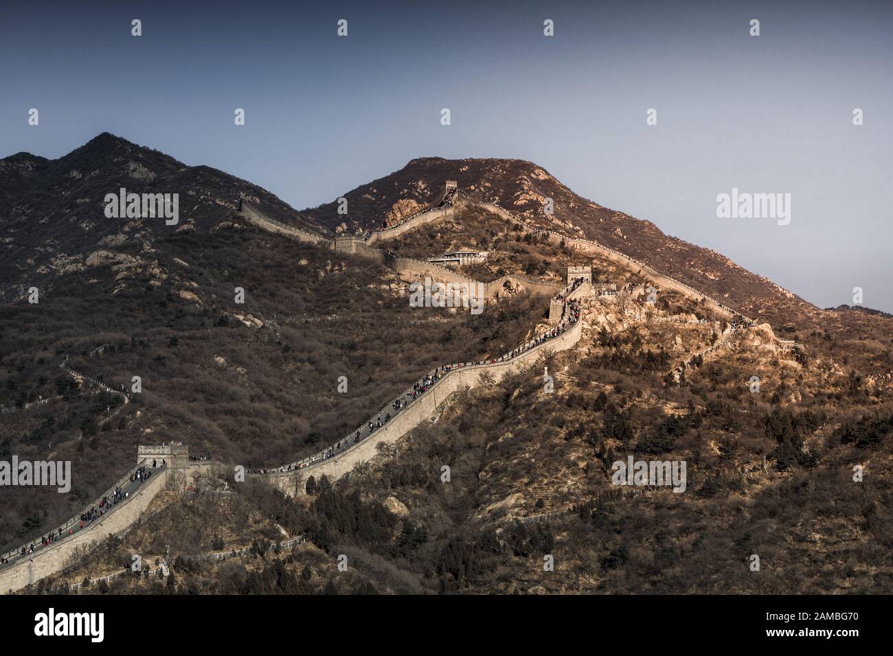 Gran Muralla China ejecuta en una montaña al atardecer. Foto de stock