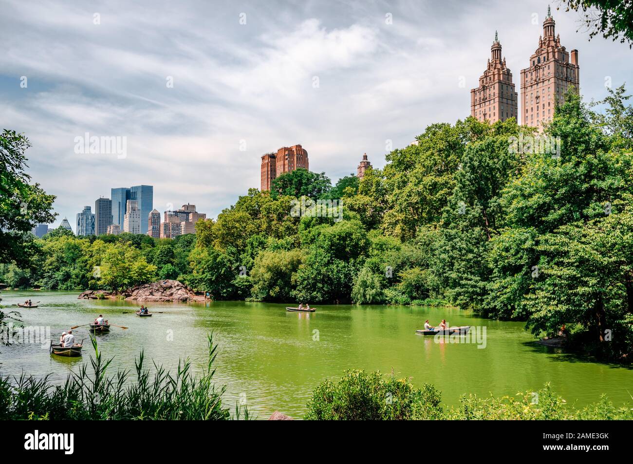 NYC, NY / EE.UU. - 12 2014 de julio: Gente fila en el Lago del Parque Central con el horizonte del West Side de Manhattan en el fondo. Foto de stock