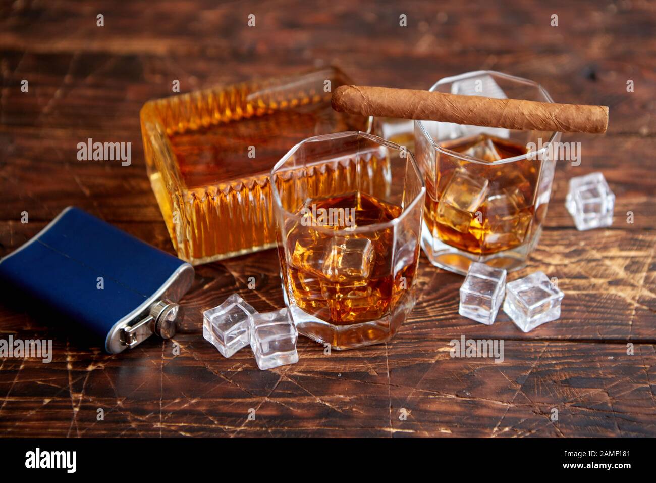 Botella de whisky con dos vasos y cigarro cubano colocado sobre mesa  rústica de madera Fotografía de stock - Alamy