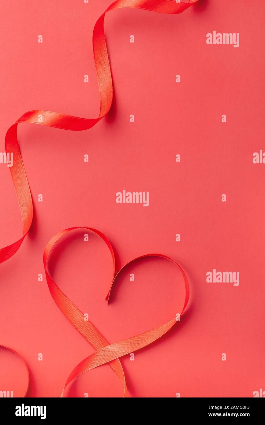 La cinta en forma de corazón sobre fondo rojo con espacio de copia. Día de San Valentín, el día de la Mujer, cumpleaños, Día de la Madre Día del concepto de tarjeta de felicitación. Espacio de copia Foto de stock