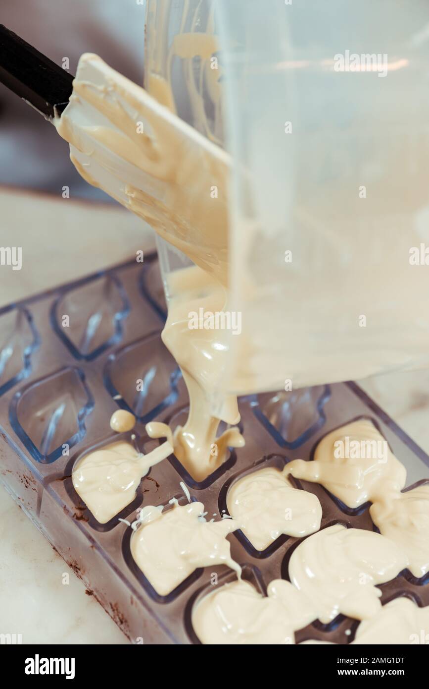 enfoque selectivo de la espátula de silicona cerca de la jarra con chocolate  blanco fundido y moldes de chocolate Fotografía de stock - Alamy