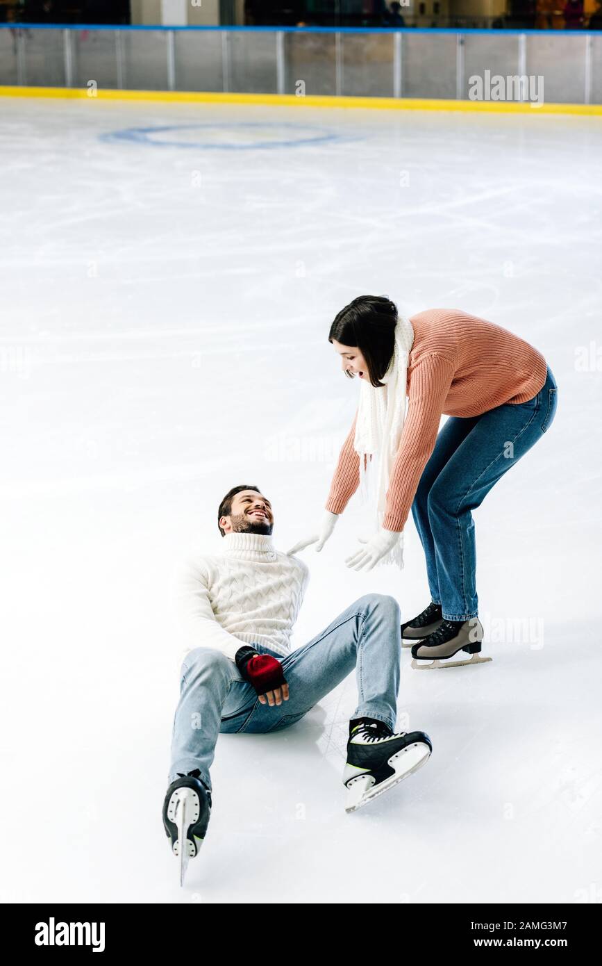 una pareja joven positiva patinando juntos mientras el hombre cae en la pista de patinaje Fotografía de stock - Alamy una pareja joven positiva patinando juntos mientras el hombre cae en la pista de patinaje Fotografía de stock - Alamy