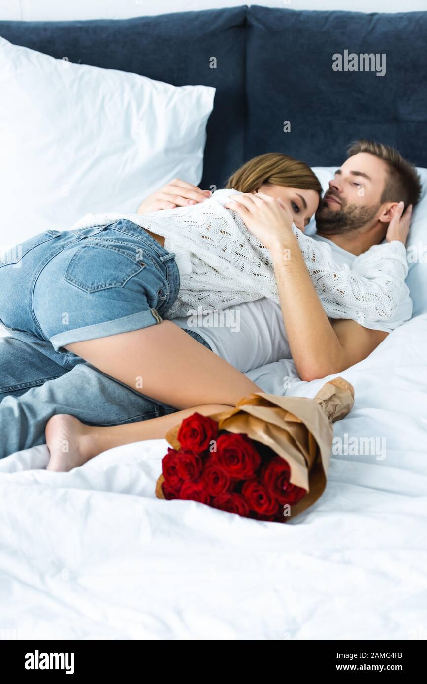 atractiva mujer en suéter abrazando a un hombre guapo en la cama Fotografía  de stock - Alamy