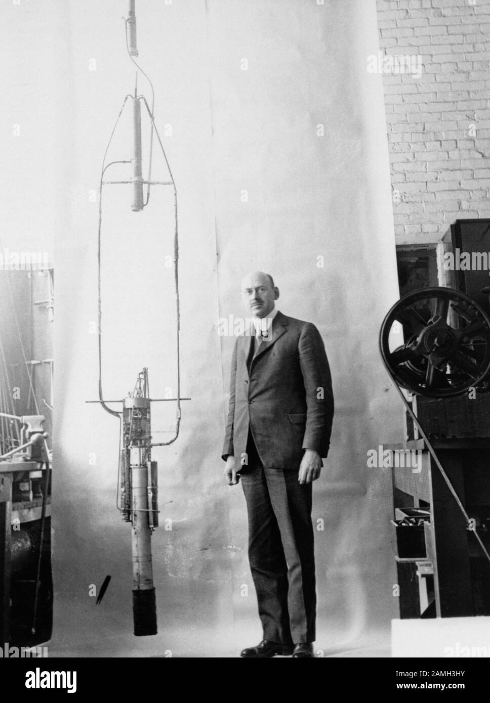 Robert Hutchings Goddard, ingeniero estadounidense, profesor, físico e inventor, se encuentra en su oficina junto a un cohete, 1820. Imagen cortesía de NASA. () Foto de stock