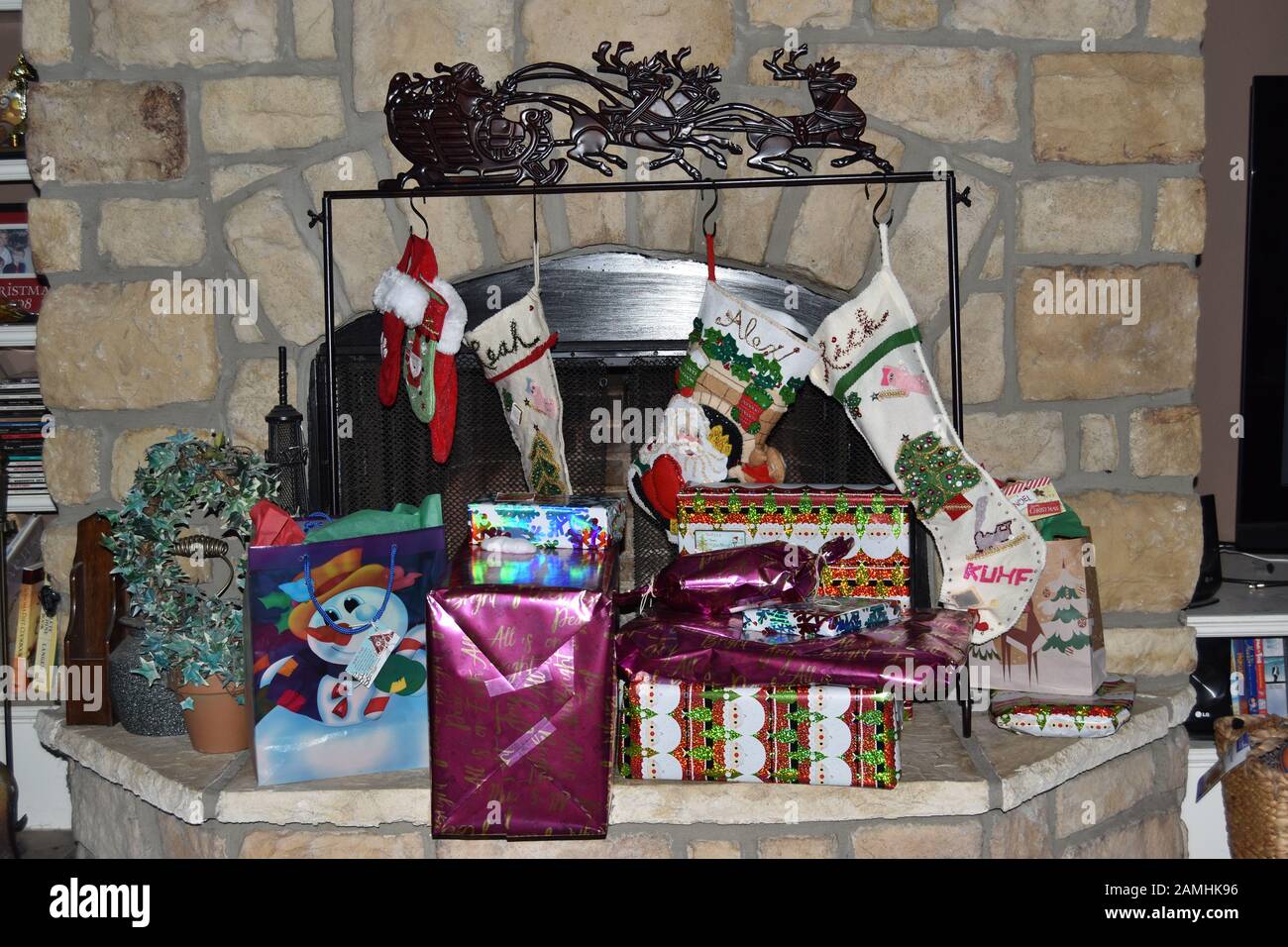 Medias de Navidad colgadas por la chimenea con regalos. Foto de stock