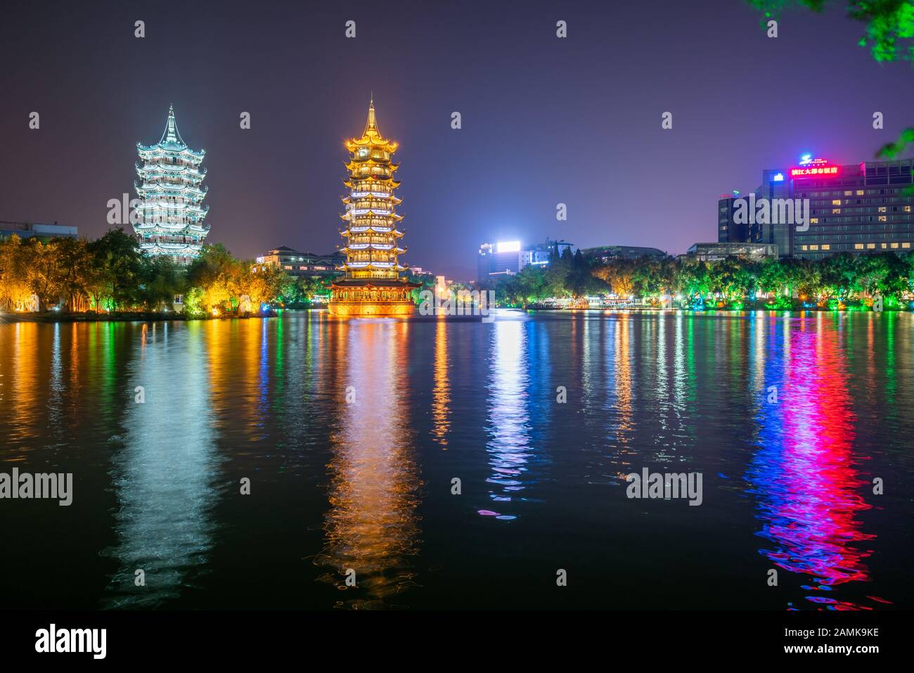Guilin, provincia de Guangxi, China - 5 de noviembre de 2019 : pagodas de sol y luna iluminadas por la noche reflejando en el lago Shanhu Foto de stock