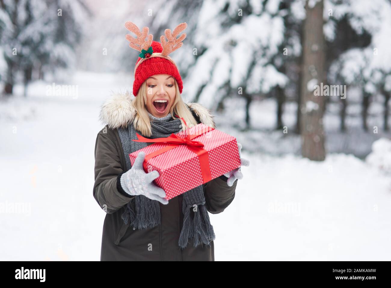 Mujer emocionada con un gran regalo de Navidad Foto de stock