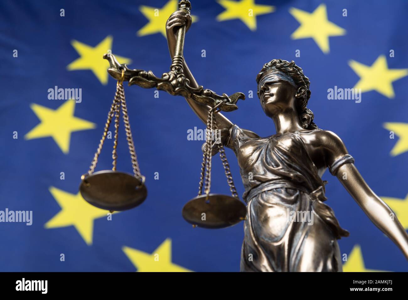 Estatua de la diosa ciega de la justicia Themis o Justitia, contra una bandera europea, como concepto legal Foto de stock