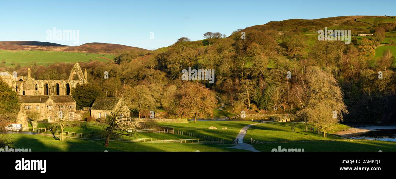 Vista rural panorámica de las antiguas y pintorescas ruinas de los prioratos monásticos, el histórico Old Rectory y las colinas iluminadas por el sol - Bolton Abbey, Yorkshire Dales, Inglaterra, Reino Unido. Foto de stock