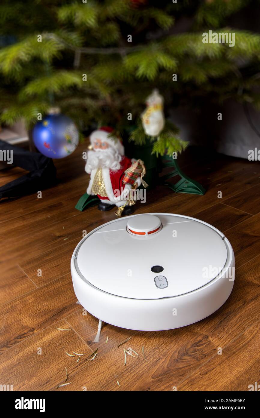 Robot aspirador limpia bajo el árbol de Navidad. El concepto de la casa  inteligente Fotografía de stock - Alamy
