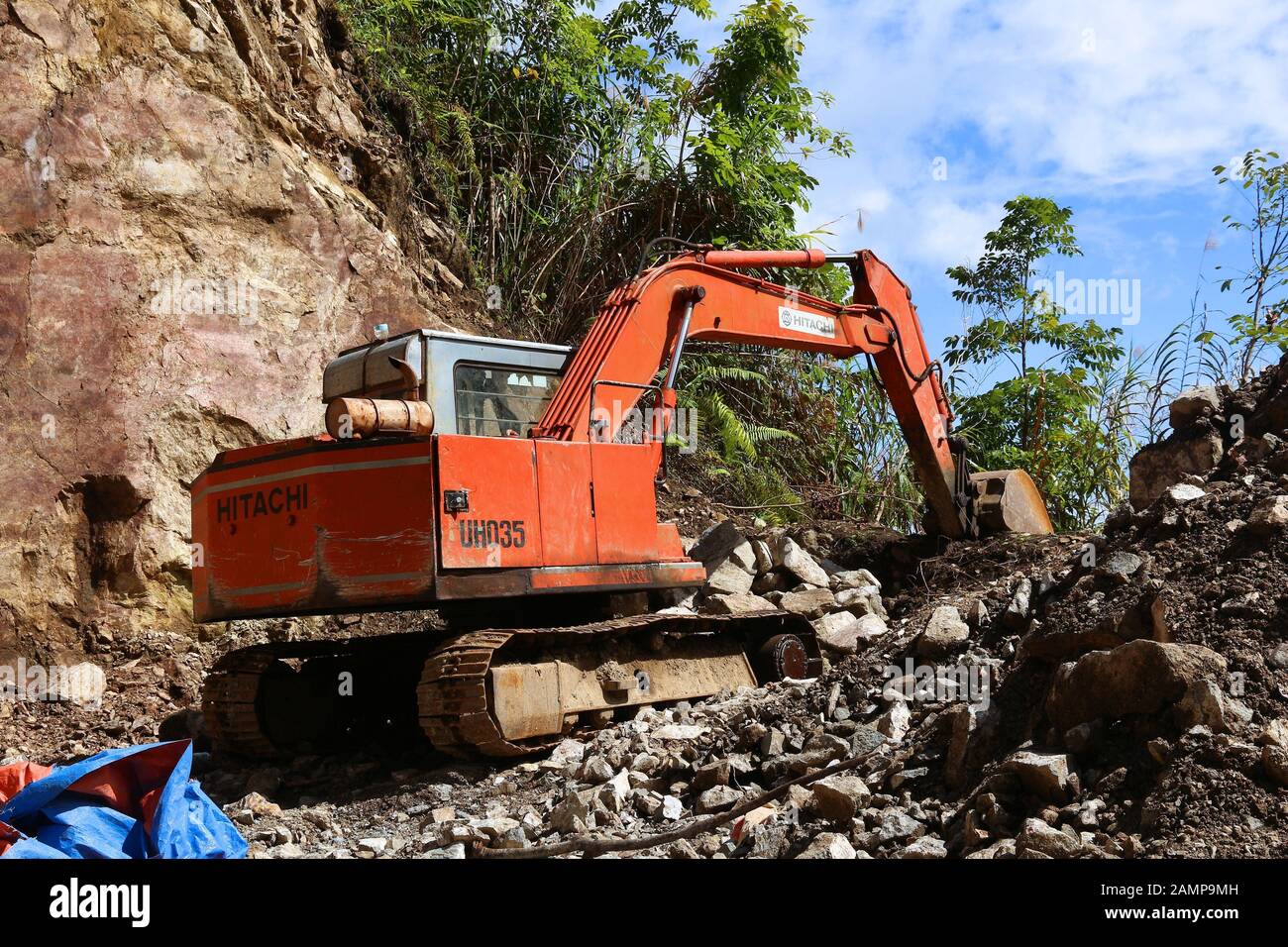 Batad, FILIPINAS - 27 DE NOVIEMBRE de 2017: Antigua excavadora Hitachi que realiza trabajos de limpieza de bloques de carreteras de roca en Batad, Filipinas. Foto de stock