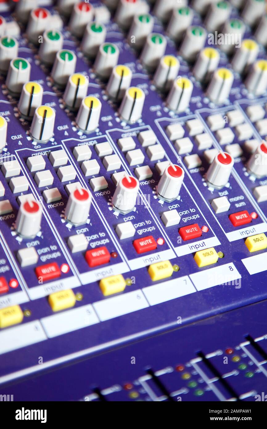 Cierre de los mandos e interruptores de una consola de mezcla de audio. Foto de stock