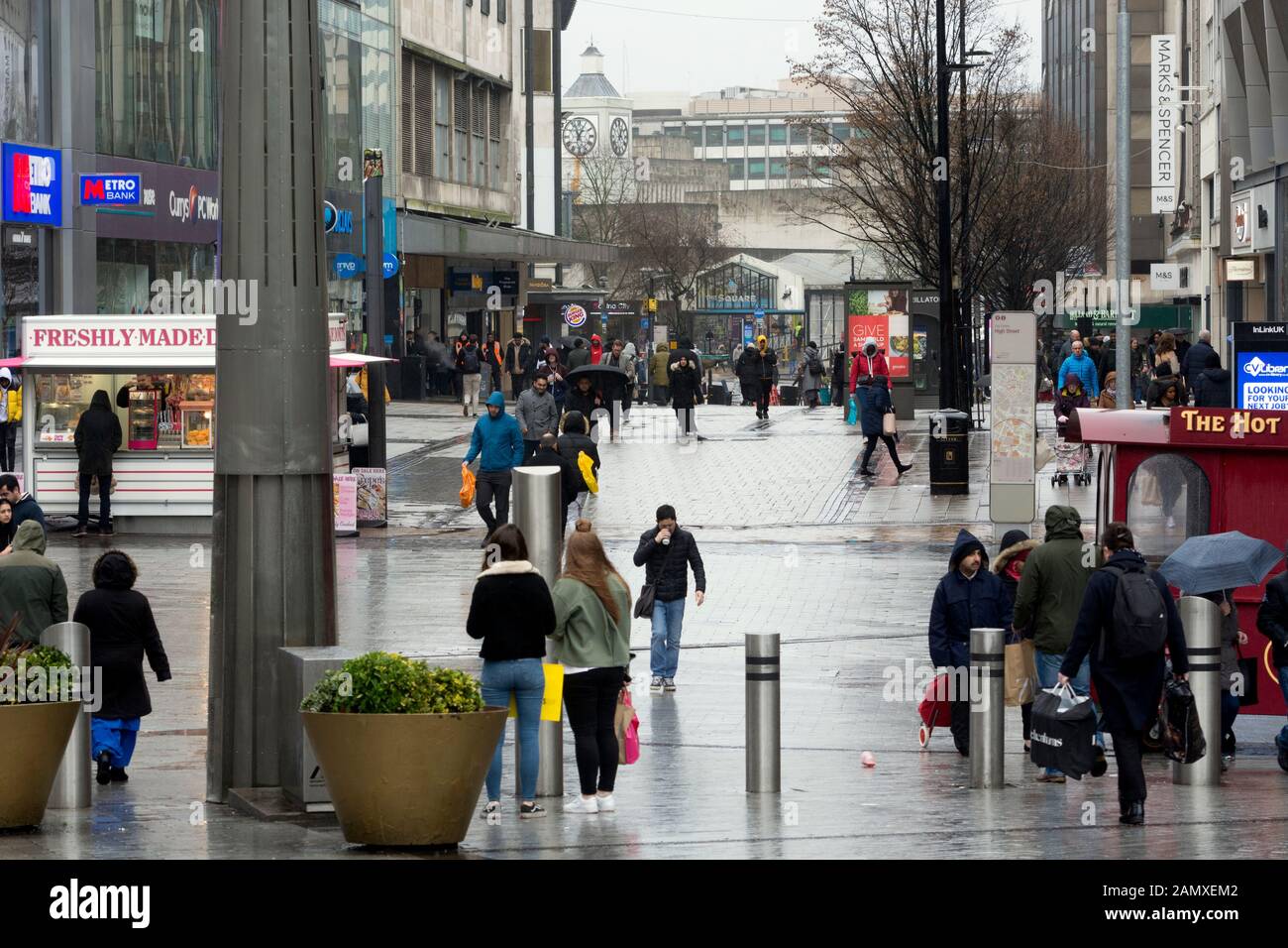 Compradores en High Street en clima húmedo en invierno, centro de la ciudad de Birmingham, Reino Unido Foto de stock