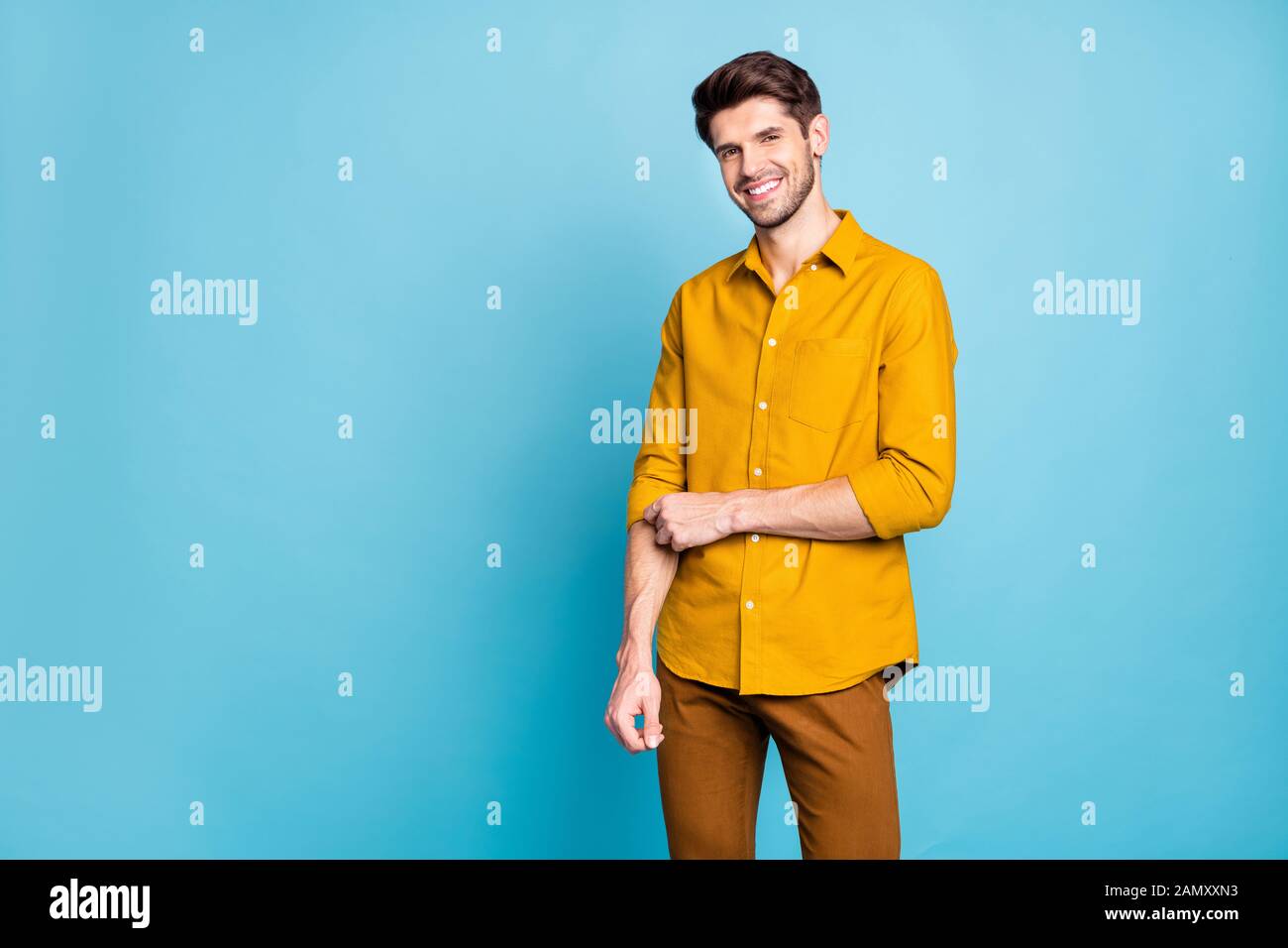 Foto de alegre atractivo guapo tocando la manga de camisa pantalones  pantalones aislado sobre fondo de color pastel azul Fotografía de stock -  Alamy