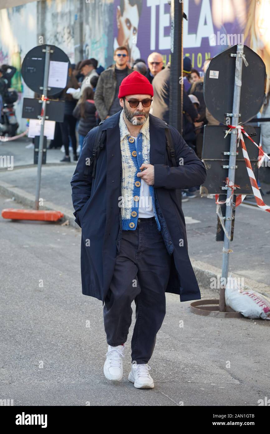 Milán, ITALIA - 11 DE ENERO de 2019: Hombre con gorra roja y abrigo azul  antes del desfile de moda de Marni, la Semana de la Moda de Milán estilo  calle Fotografía