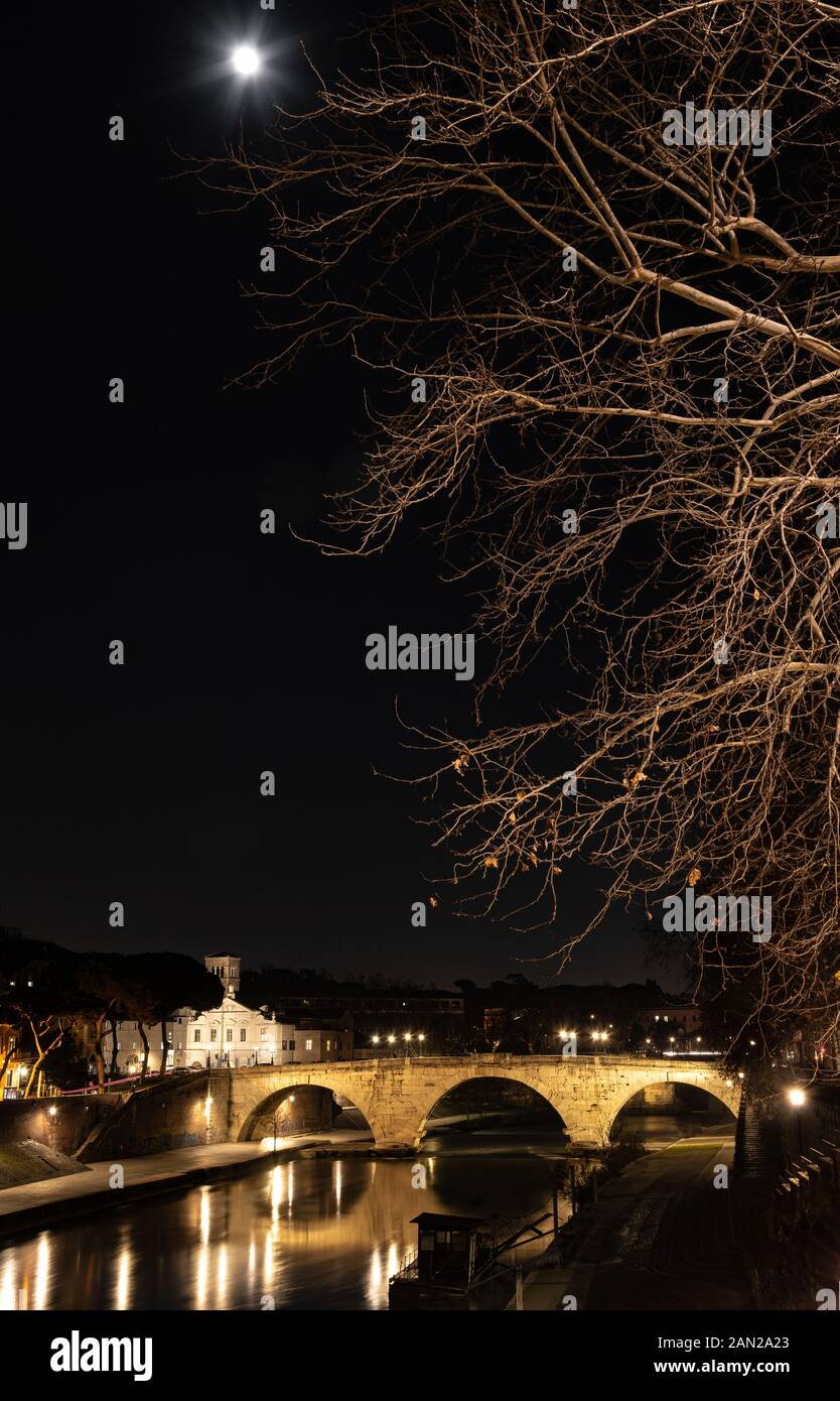 Roma, Italia, Europa: la silueta de la ciudad de noche con vista de Ponte Cestio (puente Cestio) sobre el río Tevere y la luna Foto de stock