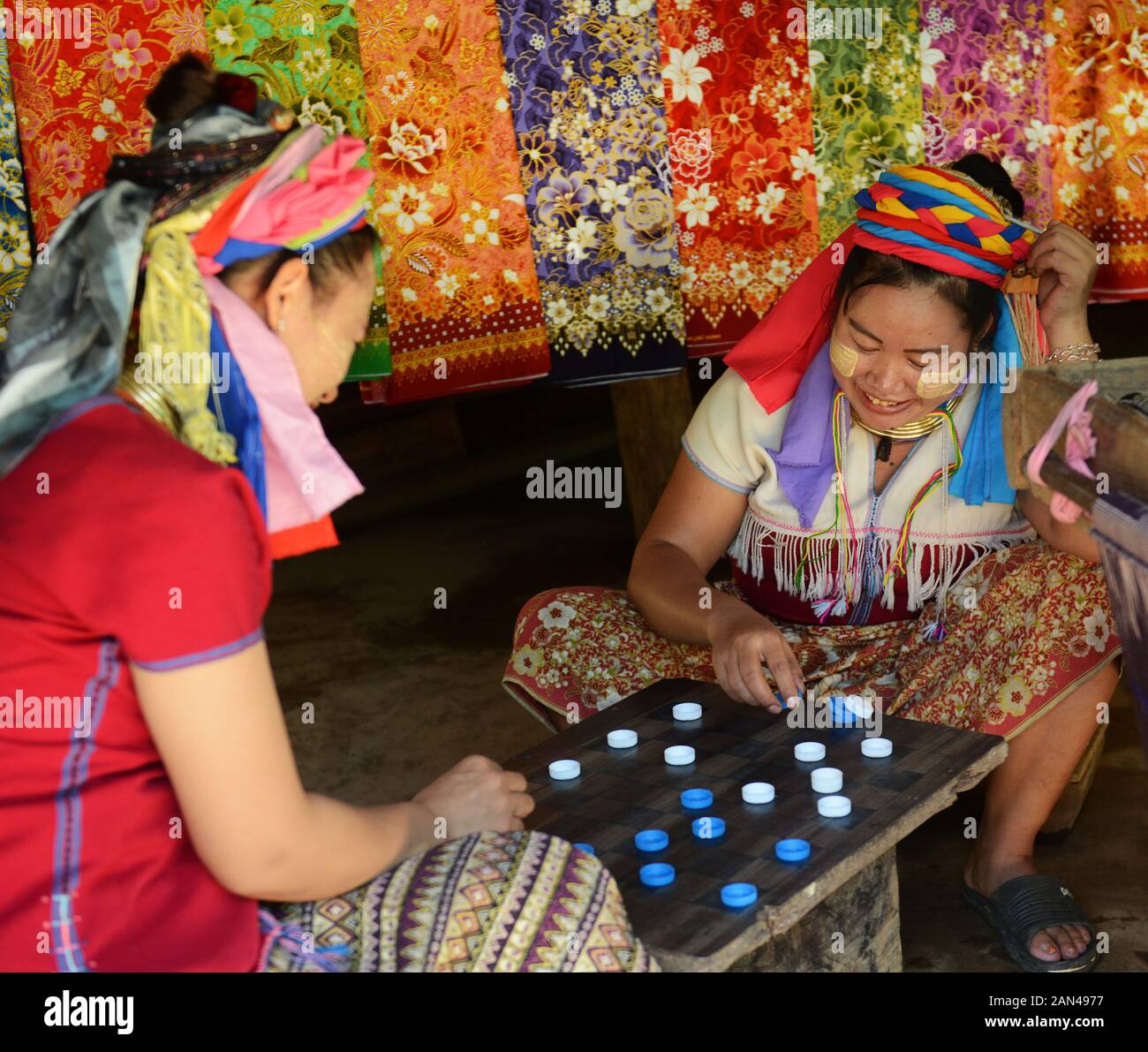Mujeres Padaung jugando un juego de mesa. Foto de stock