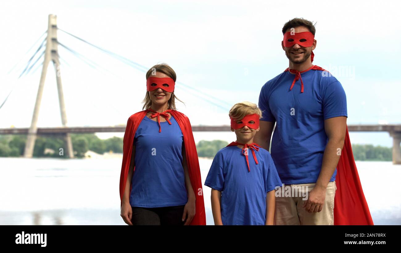 Familia en Superman disfraces posando para la cámara, el apoyo de los padres  y el concepto de cuidado Fotografía de stock - Alamy