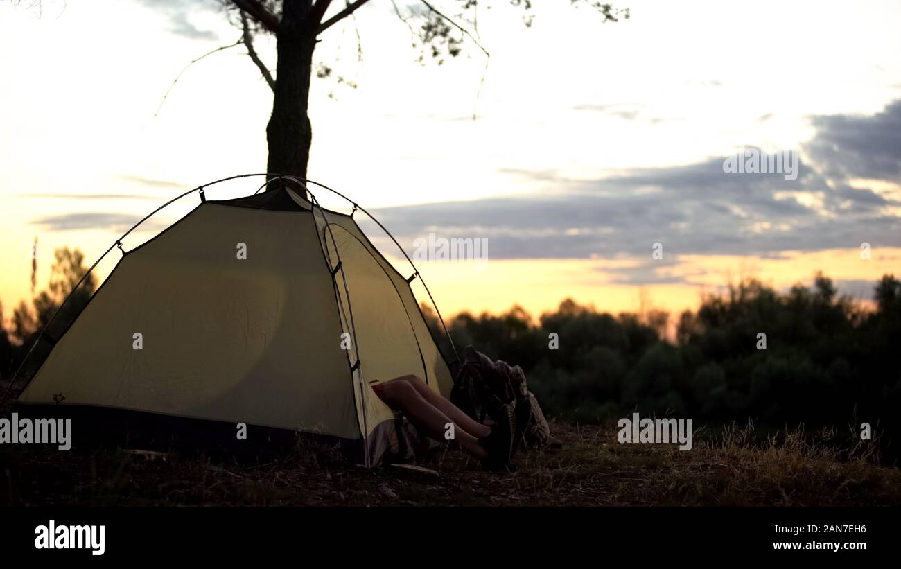 Camper descansando en la carpa temprano en lugar pintoresco, de la noche a la mañana, Amanecer en el medio silvestre Foto de stock