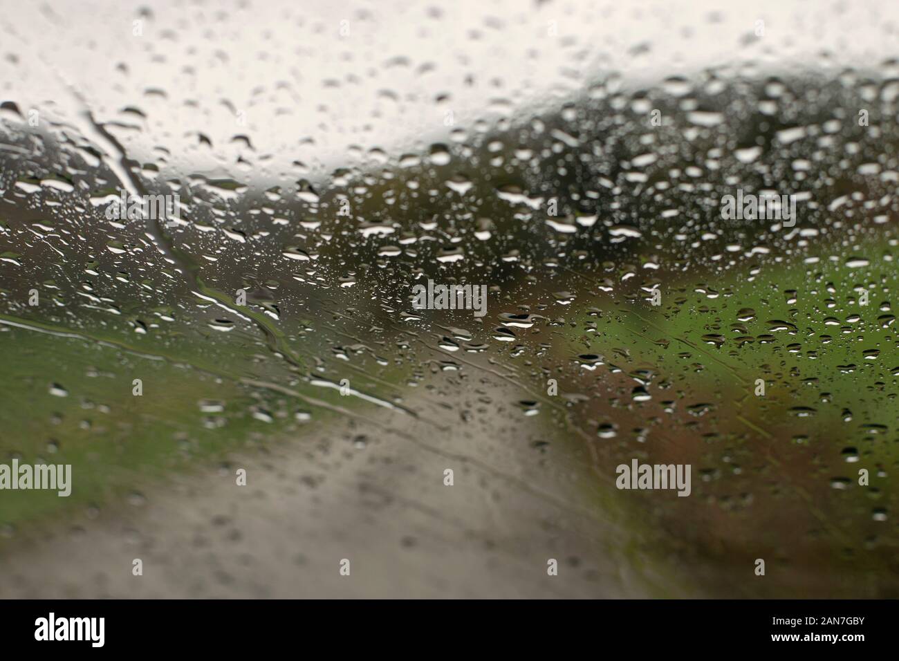 Las gotas de lluvia sobre la superficie de cristal de coche Foto de stock