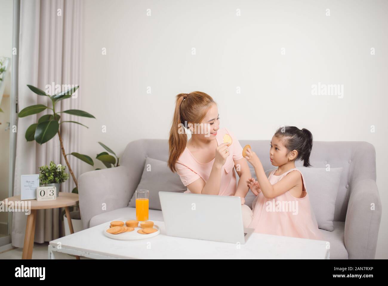 Hermosa madre y niño mira la pantalla del portátil pasar tiempo en la cocina utilizando app education program Foto de stock