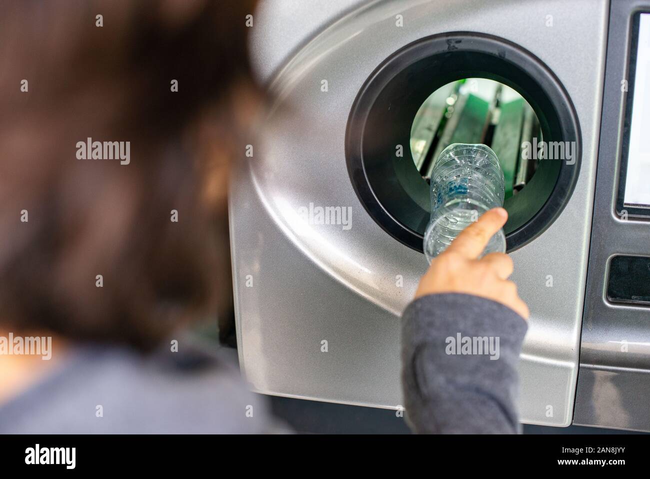 Mujer en el retroceso de la máquina expendedora de botellas de plástico reciclado, ecología concepto Foto de stock