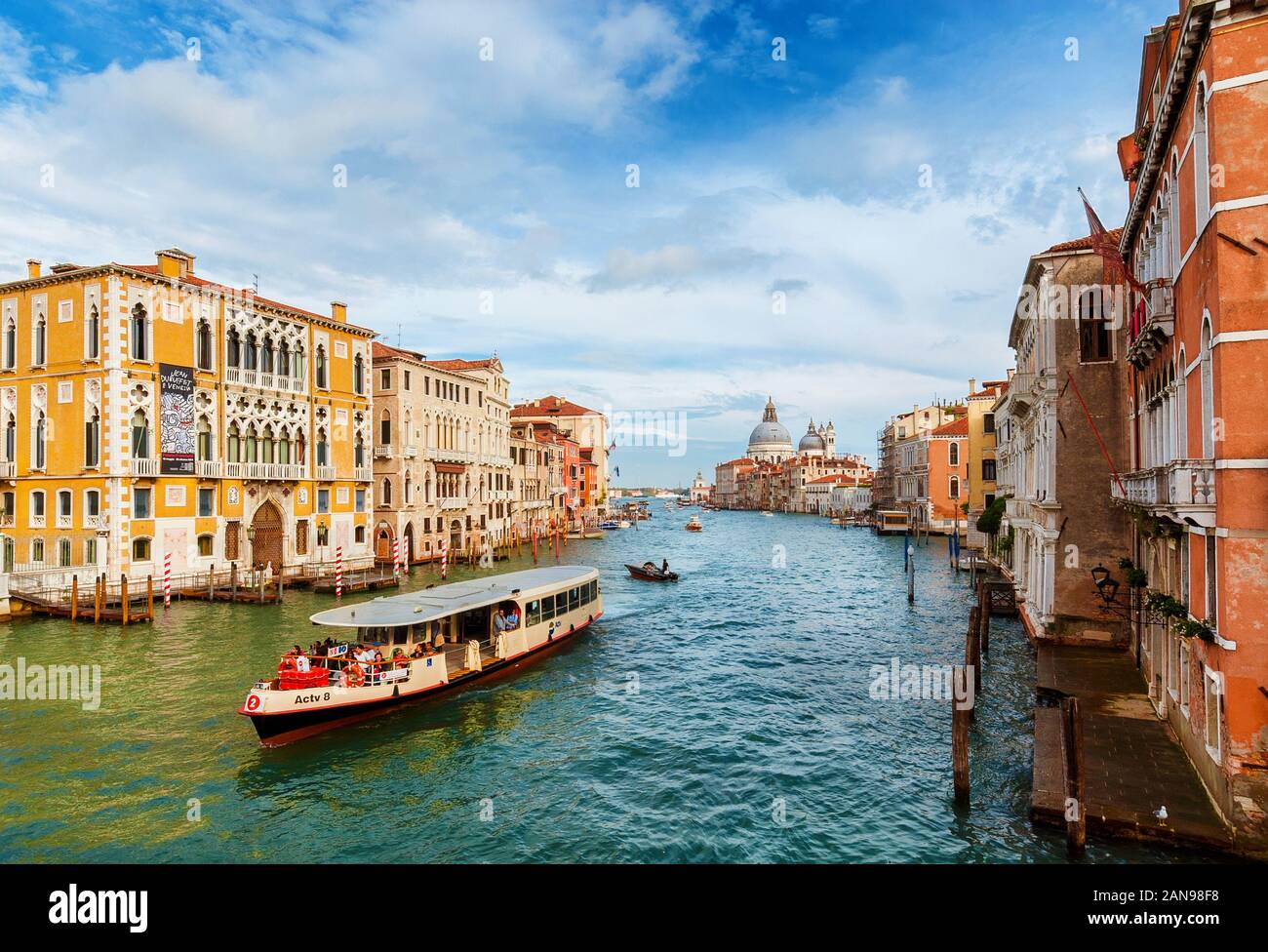 Transporte público y turismo en Venecia. N.2 de la línea de ferry cruzan el Gran Canal y cerca de la icónica Salute Basílica y el Puente de la Accademia Foto de stock